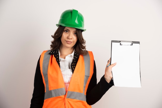 Woman engineer holding clipboard on white