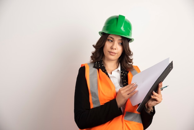 Woman engineer looking through notebook on white