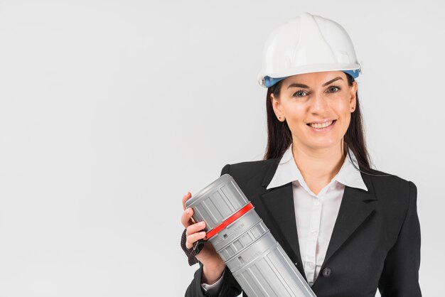 Woman engineer in white helmet holding tube