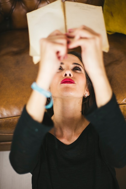 Foto gratuita donna che gode del libro vicino al divano