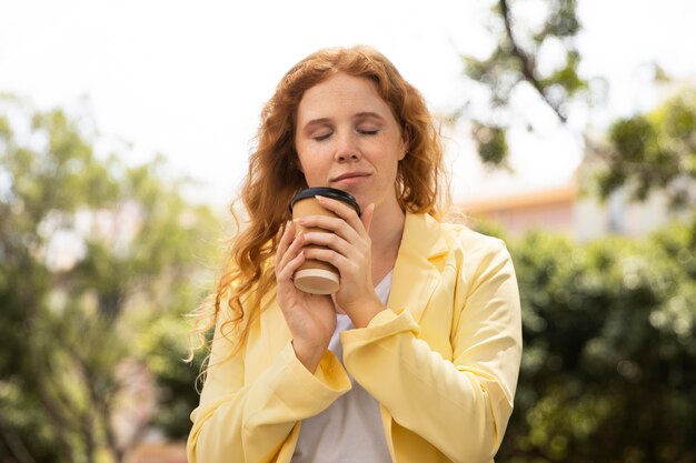 야외에서 커피 한 잔을 즐기는 여자