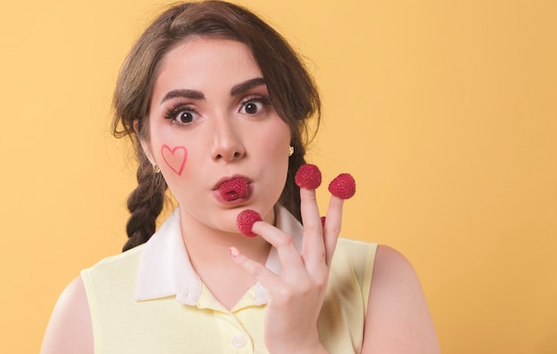 Woman enjoying eating raspberries off of her fingers