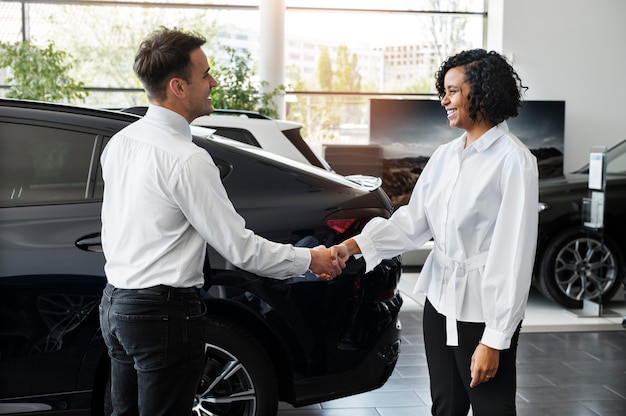 Foto gratuita donna che gode della sua indipendenza finanziaria durante l'acquisto di un'auto