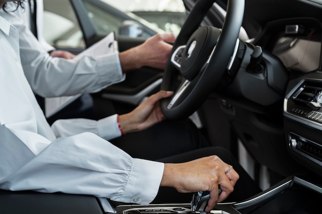 Foto gratuita donna che gode della sua indipendenza finanziaria durante l'acquisto di un'auto