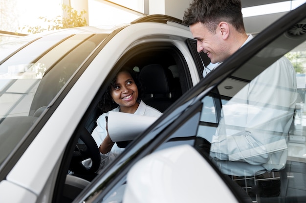 Foto gratuita donna che gode della sua indipendenza finanziaria durante l'acquisto di un'auto