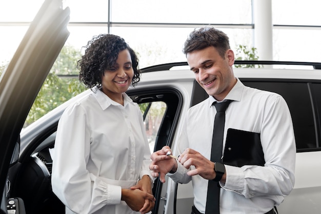 Foto gratuita donna che gode della sua indipendenza finanziaria durante l'acquisto di un'auto