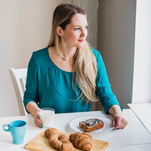 Woman enjoying milk and pastry