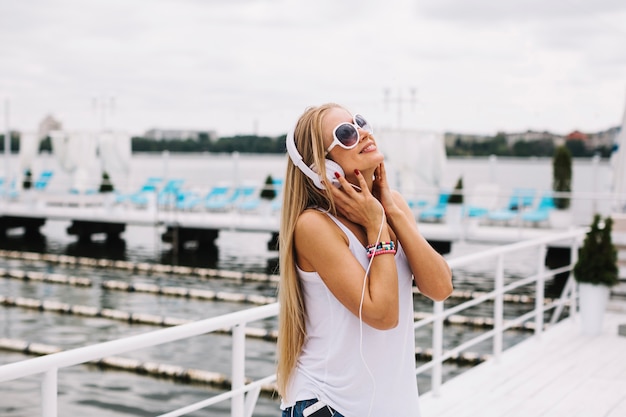 Free photo woman enjoying music near river