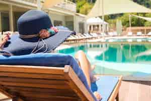Foto gratuita donna che gode e che si distende sulla sedia a sdraio in piscina
