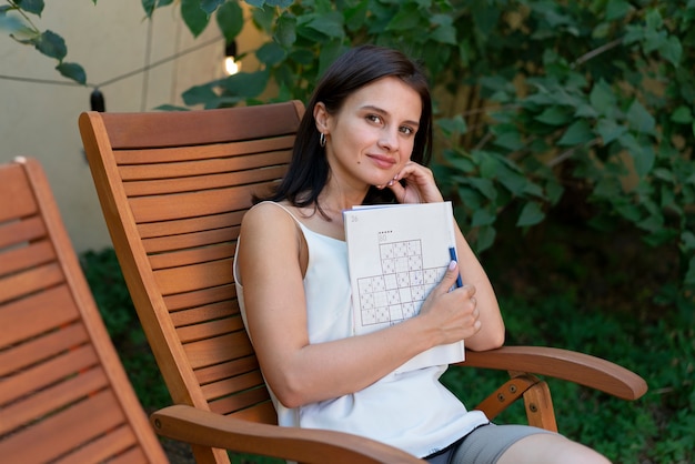 Free photo woman enjoying a sudoku game on paper by herself