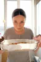 Бесплатное фото Женщина наслаждается запахом свежеиспеченного пирога