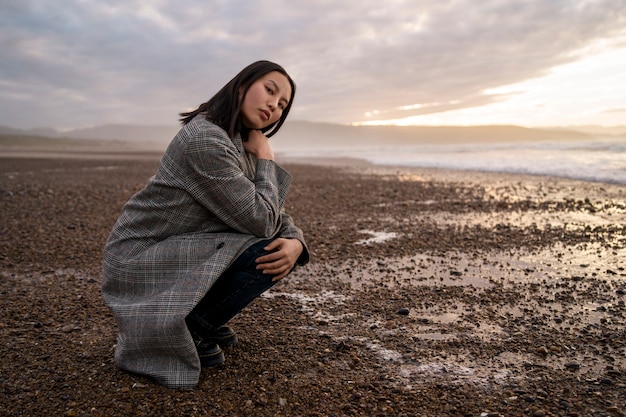 Free photo woman enjoying time at beach full shot