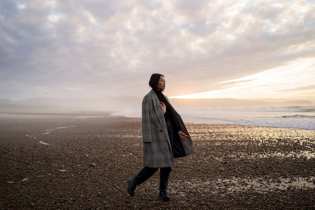 Free photo woman enjoying time at beach full shot