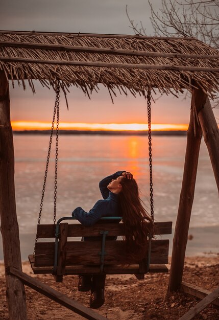 Женщина, наслаждаясь время отдыха у красивого озера на рассвете