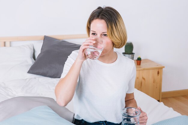 ベッドで水を楽しむ女性