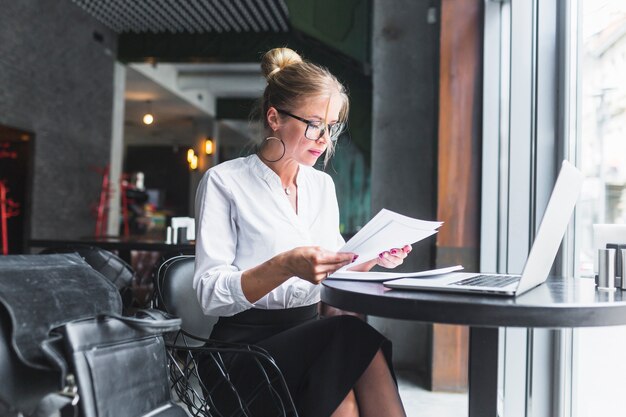 Woman examining document in restaurant