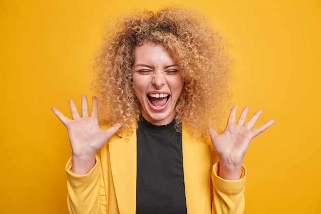 Foto gratuita la donna esclama felice si sente eccitata tiene i palmi alzati vestita con abiti formali pose