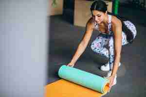 Free photo woman exercing at the gym holding yoga mat