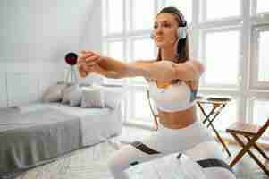 Бесплатное фото Женщина тренируется дома и слушает музыку