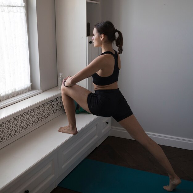 Woman exercising in front of window