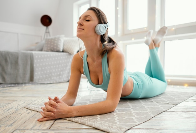 Woman exercising on mat and listening music