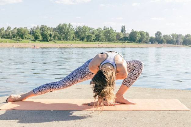 Free photo woman exercising and meditating at river