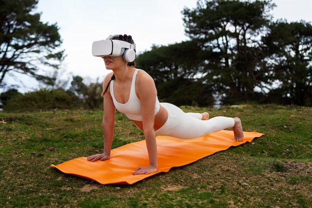 Foto gratuita donna che si esercita all'aperto nella natura con gli occhiali vr