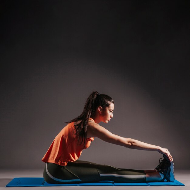 Woman exercising on stretching mat