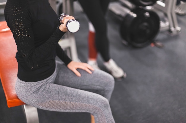 Woman exercising with dumbbell in fitness center