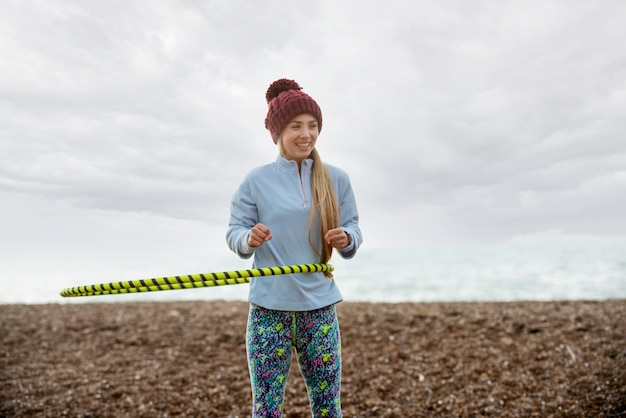 Free photo woman exercising with hula hoop circle