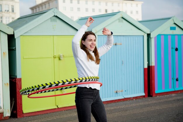 Free photo woman exercising with hula hoop circle