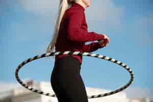 Free photo woman exercising with hula hoop circle