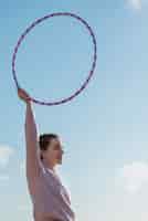 Free photo woman exercising with hula hoop circle