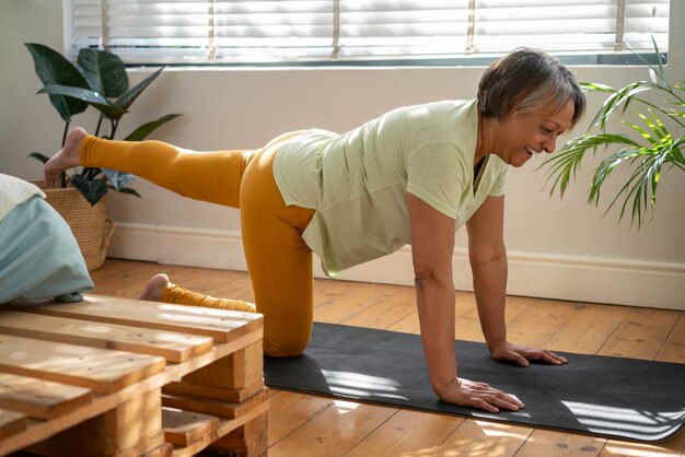 Woman exercising on yoga mat full shot