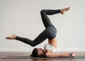 Foto gratuita donna che esercita posizioni yoga sulla stuoia