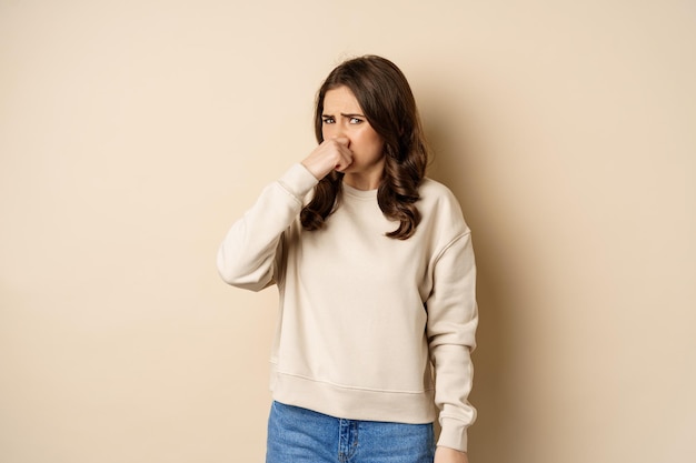 Foto gratuita donna che esprime disgusto per il cattivo odore disgustoso chiudere il naso e fare smorfie per l'antipatia in piedi sopra ...