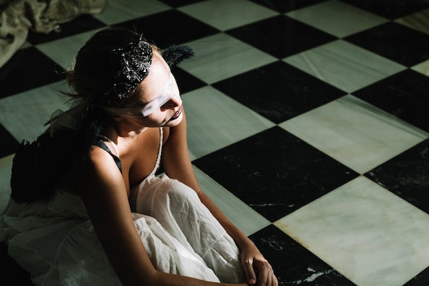 Woman in eye bondage sitting on floor