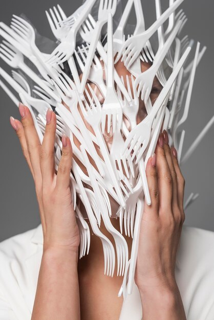 白いプラスチックのフォークで覆われている女性の顔