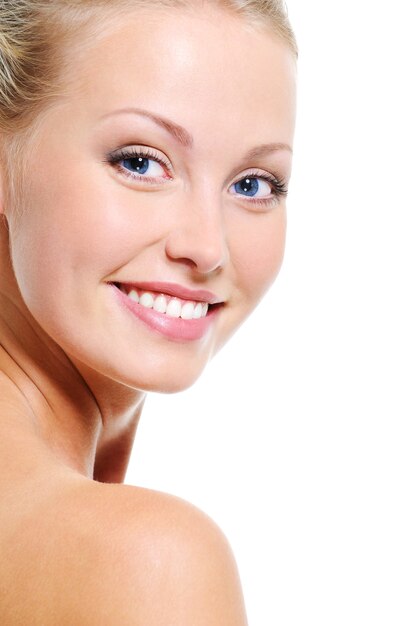 Woman face with a nice smile and healthy beautiful clear skin over white backgrouns