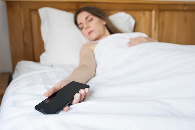 Бесплатное фото Женщина засыпает после того, как потратила время на свой телефон