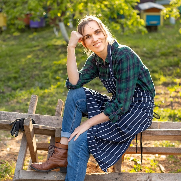 Woman farmer relaxing on a fence