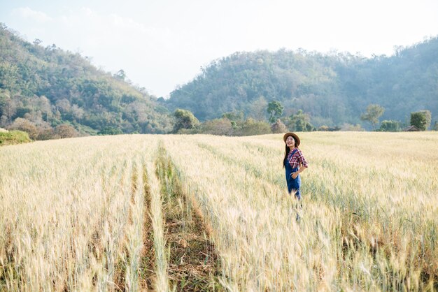 大麦畑の収穫シーズンを持つ女性農家