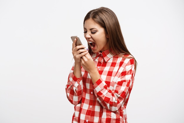 Woman in fashion spring look screaming at phone looking mad