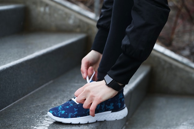 A woman fasten her shoelaces. Person fastening shoelaces.