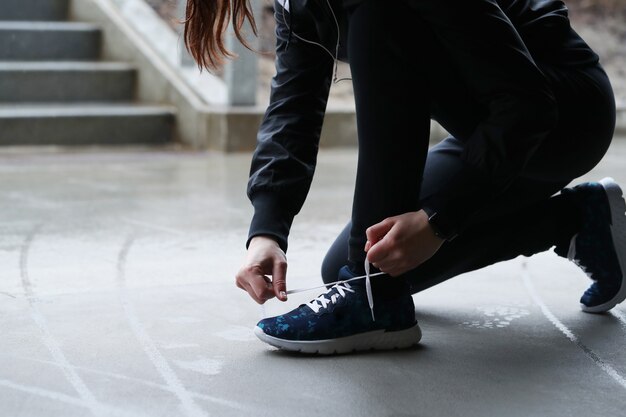 A woman fasten her shoelaces. Person fastening shoelaces.