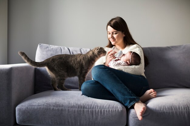 Woman feeding child on couch