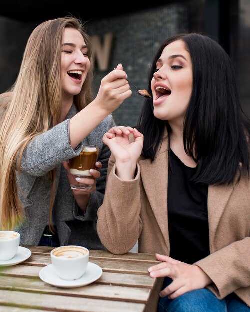 彼女の友人に彼女のデザートを給餌する女性