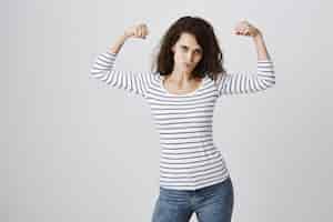Free photo woman feeling empowered flexing biceps after workout