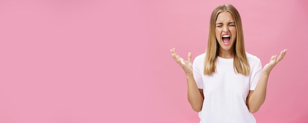 Woman feeling fed up having mental breakdown during deadline yelling with closed eyes raising hands