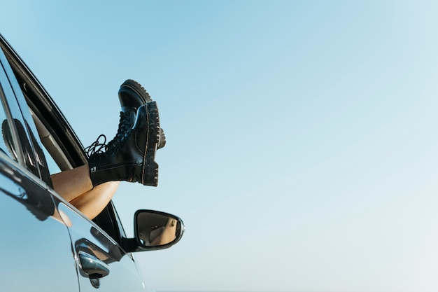 Woman feet out of car window near sea